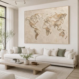 Op de afbeelding: Een groot rechthoekig wandkunstwerk met een getextureerde, driedimensionale wereldkaart in tinten beige, crème en lichtbruin. De continenten zijn verhoogd tegen een neutrale achtergrond, wat een tactiel reliëfeffect op het canvas creëert.