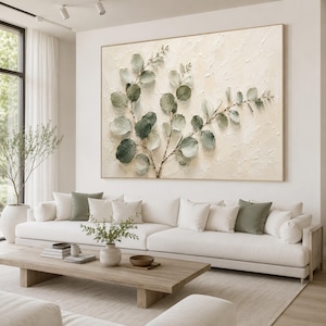 May include: A large rectangular wall art piece featuring a textured cream-colored background with a central botanical illustration of eucalyptus branches. The leaves are painted in various shades of sage and forest green with visible brushstrokes.