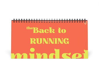 Puede incluir: Un cuaderno de espiral horizontal con una cubierta de color naranja vibrante. El texto "the Back to RUNNING mindset" está impreso en letras amarillas grandes y negritas en la parte frontal. Un pequeño icono de corazón blanco es visible en la esquina superior derecha.