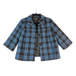 May include: A black and blue plaid jacket with a button closure.