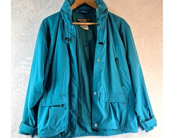 May include: A teal blue lightweight jacket with a zipper and button closure. The jacket has a hood and two pockets on the front.