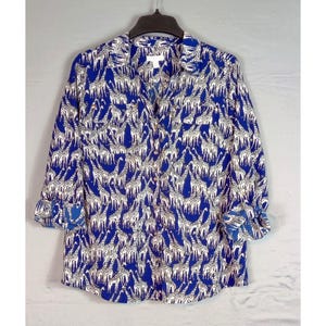 Op de afbeelding: Een blauw en wit lang mouw overhemd met knopen en een giraffenprint.
