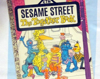 May include: A vintage Sesame Street children's book titled "The Together Book" featuring Big Bird, Cookie Monster, Elmo, and other characters. The book cover is yellow, red, and blue with a white background.