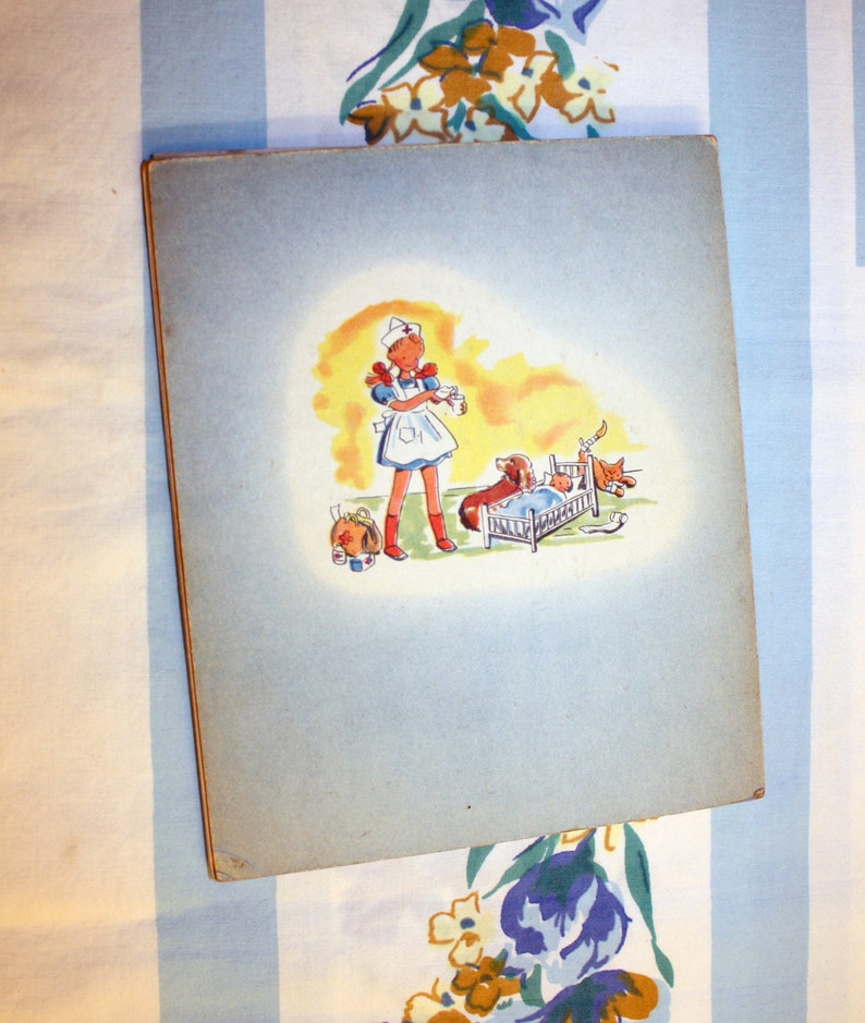 May include: A vintage children's book illustration featuring a young girl dressed as a nurse, holding a bottle and standing next to a small bed with a dog and a cat inside. The illustration is on a light blue background.