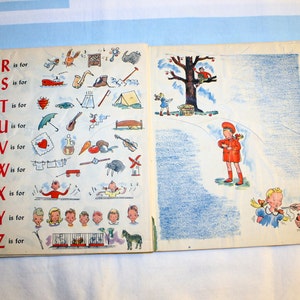 May include: An open book with colorful illustrations of the alphabet and objects starting with each letter. The book is open to the page with the letters R, S, T, U, V, W, X, Y, and Z. The illustrations include a rabbit, a ship, a tent, an umbrella, a vase, a wagon, a xylophone, a yo-yo, and a zebra.