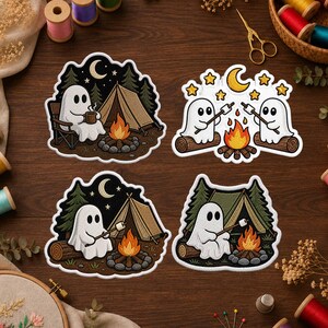 May include: Four embroidered patches featuring white ghosts in camping scenes. One ghost sits by a tent with a mug, another pair roasts marshmallows by a fire, and two individual ghosts roast marshmallows in front of green and brown tents.