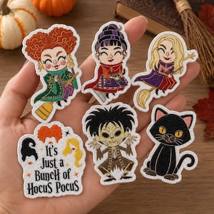 May include: Six embroidered patches featuring cartoon characters and a black cat. One patch displays the text "It's Just a Bunch of Hocus Pocus" with stylized hair icons. The designs include three witches, a spiky-haired character, and a black cat.