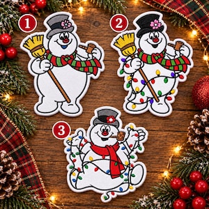 May include: Three embroidered patches featuring a snowman character wearing a top hat with a flower, a scarf, and holding a broom and a pipe. Patch 1 has a red and green scarf. Patch 2 and 3 include colorful string lights wrapped around the snowman.