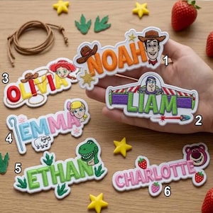 Può includere: Sei toppe ricamate con nomi e motivi di personaggi dei cartoni animati. Le toppe mostrano i nomi Noah, Liam, Olivia, Emma, Ethan e Charlotte, ciascuna accompagnata da icone a tema come cappelli da cowboy, ranger spaziali, pecore, dinosauri e fragole.