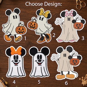 May include: Six embroidered patches featuring cartoon characters dressed as ghosts for Halloween. Each design shows a character with mouse ears, some holding orange jack-o'-lantern buckets, and some wearing bows. The text Choose Design is at the top.