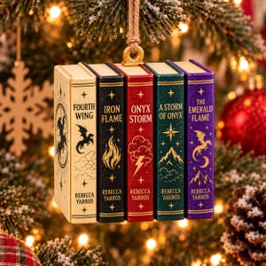 May include: A hanging ornament featuring five miniature book spines titled Fourth Wing, Iron Flame, Onyx Storm, A Storm of Onyx, and The Emerald Flame by Rebecca Yarros. Each spine displays unique gold foil illustrations of dragons, flames, clouds, lightning, and mountains.