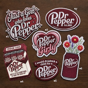 May include: Six embroidered patches featuring Dr Pepper branding. Designs include heart-shaped text, the classic logo, a pack of cigarettes labeled Fridge Cigs, a humorous quote, and a soda can with red and purple flowers, all in shades of maroon.