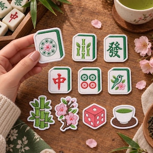 May include: A collection of embroidered patches featuring Mahjong tiles, bamboo stalks, cherry blossoms, a red die, and a cup of green tea. The patches are white with green borders, showcasing various symbols including circles, bamboo, and Chinese characters.