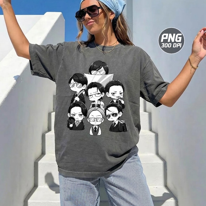 May include: A charcoal grey short-sleeve t-shirt featuring a graphic print of seven chibi-style characters in suits and glasses. The design is rendered in black and white, showcasing various expressions and poses. The shirt has a relaxed, loose fit.