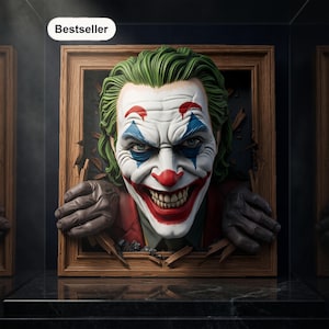 Puede incluir: Una pieza de arte mural tridimensional que presenta un personaje Joker esculpido con cabello verde, pintura facial blanca, marcas azules en los ojos y una sonrisa roja. La figura parece romper un marco de madera con las manos visibles.