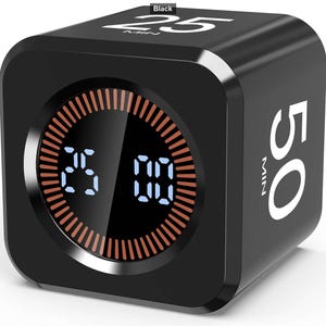 May include: A black cube-shaped digital timer with rounded edges. The top face displays the text 25 MIN, and the side face displays 50 MIN. The front circular display shows a digital countdown of 25:00 with a glowing orange ring of tick marks.
