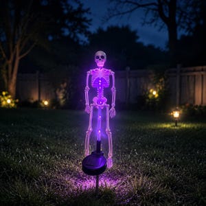 May include: A light-up skeleton garden stake featuring a white plastic skeletal frame illuminated by bright purple LED lights. The figure is mounted on a black circular solar-powered base with a stake, designed for outdoor placement in the grass.