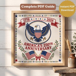 Op de afbeelding: Een kruissteekpatroon met een centrale Amerikaanse zeearend met schild, geflankeerd door twee Amerikaanse vlaggen. De tekst luidt 1776, 2026 en AMERICA'S 250TH ANNIVERSARY. Het ontwerp is omlijst door een rand van groene bladeren en blauwe sterren.
