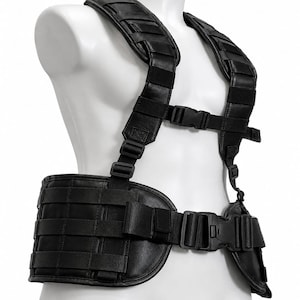 Könnte beinhalten: Ein schwarzes taktisches Tragesystem mit einem breiten Hüftgurt und Schultergurten aus lederartigem Material. Das Design umfasst integrierte Nylon-Gurtbandschlaufen, verstellbare Nylonriemen und schwarze Kunststoff-Steckschnallen.