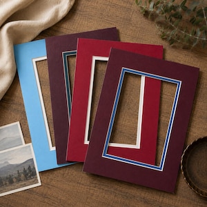 Peut inclure: Un ensemble de quatre passe-partout rectangulaires pour cadres photo, déclinés en bleu clair, violet foncé, rouge vif et bordeaux. Chaque passe-partout présente une ouverture centrale rectangulaire avec un bord intérieur blanc ou bleu.