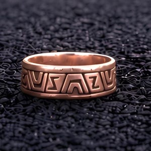 May include: A copper-toned metal ring featuring a continuous band with a repeating geometric pattern of recessed angular shapes and lines. The ring has a smooth, polished finish and a consistent width throughout its circular structure.
