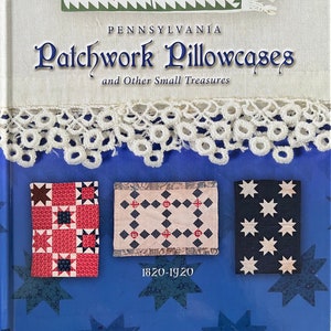 May include: A book titled "Pennsylvania Patchwork Pillowcases and Other Small Treasures" with a blue cover. The cover features examples of patchwork designs and the text "1820-1920". The author's name, Ann R. Hermes, and the publisher's logo are also visible.