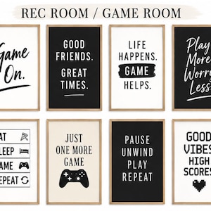 Puede incluir: Una colección de ocho láminas de arte mural rectangulares en marcos de madera clara, con tipografía en blanco y negro e iconos de temática de juegos. Las láminas muestran frases como Game On, Good Friends Great Times, Life Happens Game Helps, Play More Worry Less, Eat Sleep Game Repeat, Just One More Game, Pause Unwind Play Repeat y Good Vibes High Scores.