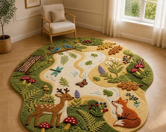 Op de afbeelding: Een groot, rond, getuft vloerkleed met een gedetailleerde bosscène met een kronkelende beek, een bruin hert, een oranje vos, diverse groene varens, rode paddenstoelen, blauwe vogels, een vlinder, een libel en kleine kikkers.