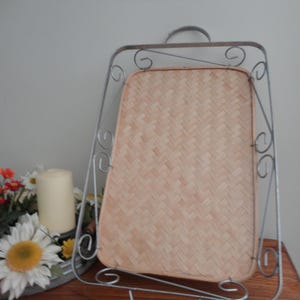 May include: A rectangular serving tray featuring a light tan woven bamboo base set within a silver-colored metal wire frame. The metal frame is accented with decorative scrollwork patterns along the sides and includes a small handle at the top.