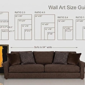 May include: A wall art size guide chart displaying various dimensions in inches, including A1-A4, ratios 2:3, 4:5, 3:4, and 1:1. Below the chart, a brown sofa is shown with a label indicating it is 84 inches wide, next to a framed poster.