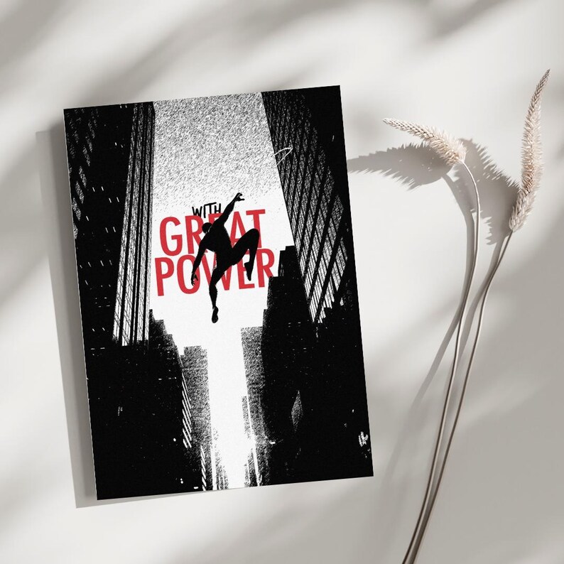 May include: A rectangular art print featuring a black silhouette of a figure leaping between tall city buildings. The text WITH GREAT POWER is printed in bold red capital letters across the center against a bright white background.