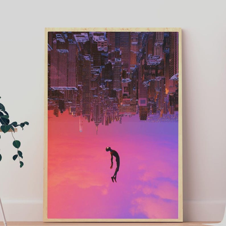 Może przedstawiać: Oprawiony wydruk przedstawiający odwr&oacute;cone miasto i spadającą postać. Budynki są brązowe i szare, na tle gradientowego nieba w kolorze r&oacute;żowym, fioletowym i pomarańczowym. Postać jest czarna z czerwoną maską.