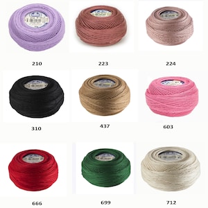May include: Nine spools of DMC embroidery floss in various colors, including lavender, pink, black, brown, pink, red, green, and beige. Each spool has a white label with the DMC logo and the number of the color.