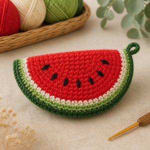 Può includere: Una pochette all'uncinetto a forma di fetta di anguria, con un centro rosso brillante, semi neri ricamati, un bordo bianco e un contorno verde scuro. La pochette è dotata di un piccolo occhiello su un lato per poterla appendere.