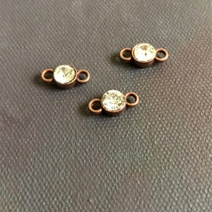 May include: Three copper-toned connector charms with clear crystal rhinestones. Each charm has two loops for attaching to jewelry.