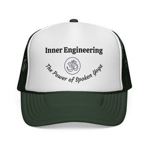 May include: A dark green and white trucker hat. The front panel is white, with the text "Inner Engineering" above an Om symbol, and "The Power of Spoken Yoga" below. The brim and mesh back are dark green.
