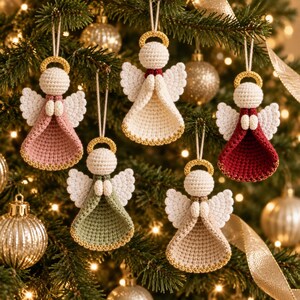 May include: Five crocheted angel ornaments hanging from a Christmas tree. Each angel features a round cream-colored head, white wings, and a dress in a different color: dusty pink, cream, sage green, beige, and deep red, all with gold trim.