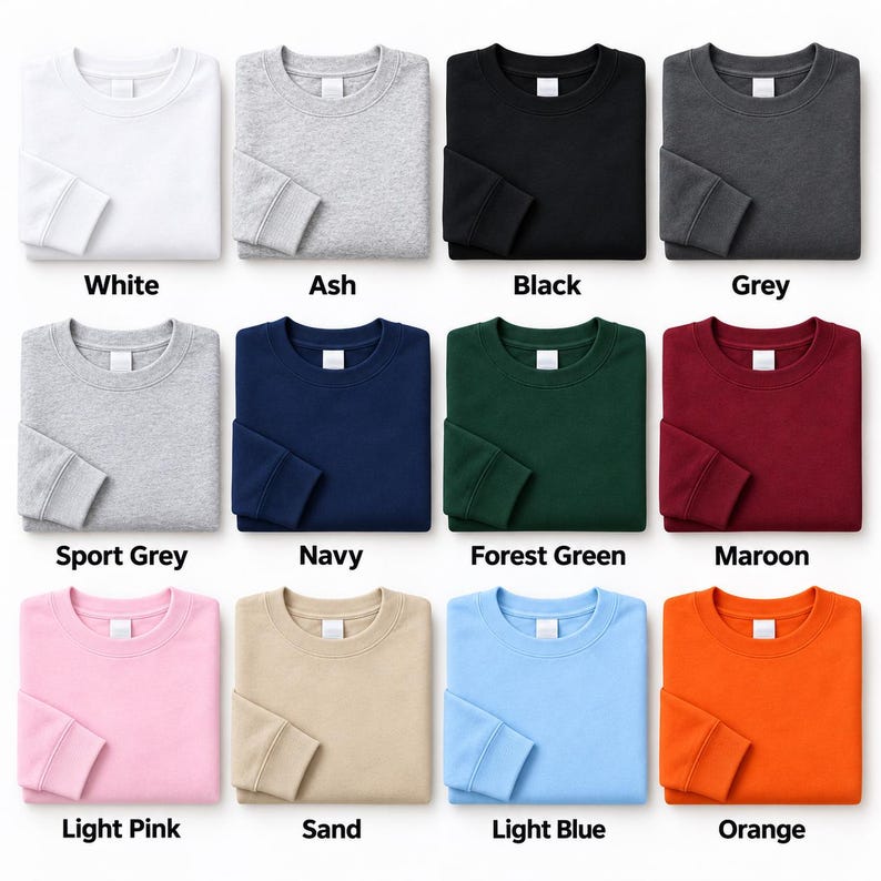 May include: A collection of twelve crewneck sweatshirts displayed in a grid, featuring solid colors including white, ash, black, grey, sport grey, navy, forest green, maroon, light pink, sand, light blue, and orange, each with a white neck label.
