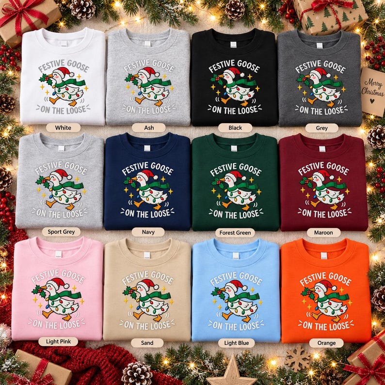 May include: A collection of twelve crewneck sweatshirts in various colors, each featuring a graphic of a goose wearing a Santa hat and a string of Christmas lights, with the text FESTIVE GOOSE ON THE LOOSE printed in white or black lettering.