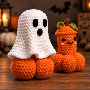 May include: A white crocheted ghost figure with black felt eyes and mouth sitting atop a round orange crocheted pumpkin, positioned next to a smaller orange crocheted pumpkin with a brown stem, green leaves, and a smiling face with pink cheeks.