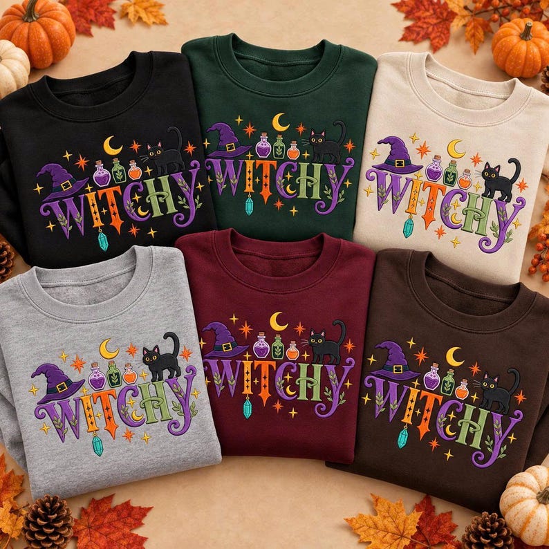 May include: A collection of six crewneck sweatshirts in black, dark green, beige, gray, maroon, and brown. Each features a graphic with the text WITCHY, a purple witch hat, a black cat, colorful potion bottles, a crescent moon, and stars.