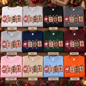 May include: A collection of twelve crewneck sweatshirts in various colors, each featuring a central horizontal graphic of four framed Christmas icons: Santa Claus, a reindeer, a nutcracker, and a gingerbread man, surrounded by snowflakes.