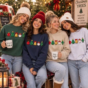 May include: Four crewneck sweatshirts in dark green, navy blue, beige, and light gray, each featuring a graphic of cartoon Christmas ornaments and trees holding hands. The wearers are also sporting matching knit beanies in white and red.