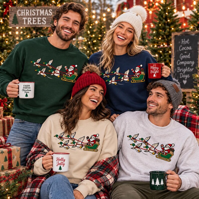 May include: Four people wearing crewneck sweatshirts featuring a graphic of Santa Claus in a sleigh pulled by flying ducks. The sweatshirts are dark green, navy blue, beige, and light gray. Each person holds a ceramic mug with holiday text and designs.