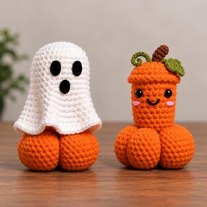 May include: Two crocheted amigurumi figures. One is a white ghost with black oval eyes and a round mouth sitting on an orange pumpkin base. The other is an orange pumpkin-shaped figure with a green stem, leaf, black eyes, and a smiling mouth.