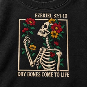 May include: A black sweatshirt featuring a graphic of a skeleton surrounded by red, yellow, and orange flowers. The text EZEKIEL 37:1-10 is printed above the graphic, and the text DRY BONES COME TO LIFE is printed below the graphic in a cream color.