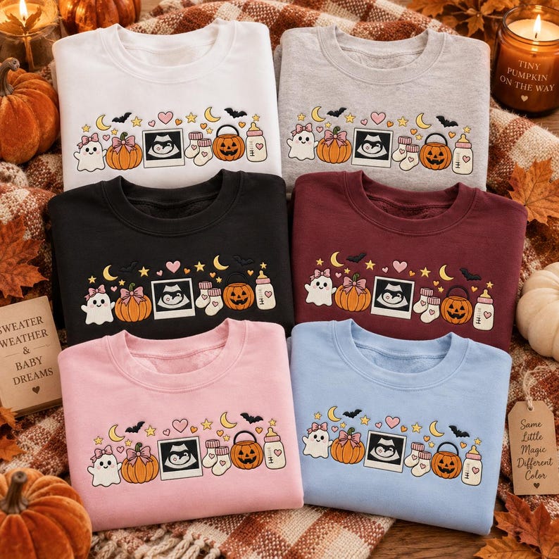 May include: Six crewneck sweatshirts in white, gray, black, maroon, pink, and light blue. Each features a screen-printed graphic of a ghost, pumpkin, ultrasound image, baby socks, jack-o'-lantern bucket, and baby bottle with stars and moons.