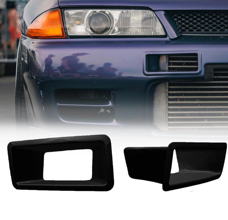 May include: Two matte black rectangular air intake ducts designed for a vehicle front bumper. These components feature a hollow center and a tapered profile, shown alongside a purple car front end with a visible headlight and front grille.