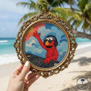 Könnte beinhalten: Ein rundes Gemälde in einem verzierten goldenen Rahmen zeigt eine rote, pelzige Figur mit schwarzem Kopfhörer und Sonnenbrille, die mit einer Hand winkt und ein schwarzes DJ-Mischpult bedient. Der Hintergrund zeigt einen blauen Himmel.
