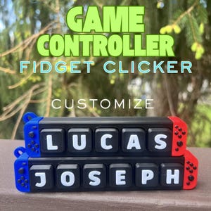 May include: Two black rectangular fidget clickers shaped like game controllers with blue left sides and red right sides. The top clicker features white keys spelling LUCAS, and the bottom clicker features white keys spelling JOSEPH. Text reads GAME CONTROLLER FIDGET CLICKER CUSTOMIZE.